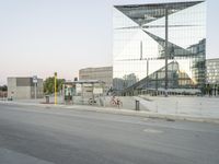 a city street with a reflection of a glass building on it with bicycles in the foreground