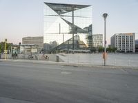 a city street with a reflection of a glass building on it with bicycles in the foreground