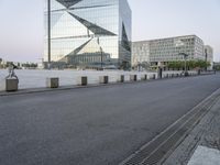 a person is riding a bike on the road near some buildings in the city with glass windows