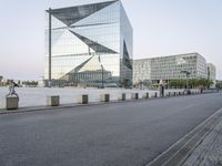 a person is riding a bike on the road near some buildings in the city with glass windows