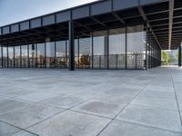 the modern building has glass walls with iron mesh on it's roof, surrounded by stone tile