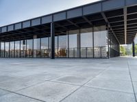 the modern building has glass walls with iron mesh on it's roof, surrounded by stone tile