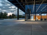 the large glass enclosed space features stone, steel and wood benches on the decking