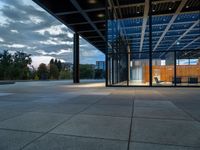 the large glass enclosed space features stone, steel and wood benches on the decking