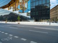 a blue and white building near a large street intersection with buildings reflected in the glass