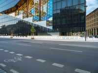 a blue and white building near a large street intersection with buildings reflected in the glass