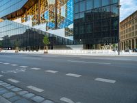 a blue and white building near a large street intersection with buildings reflected in the glass