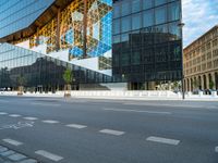 a blue and white building near a large street intersection with buildings reflected in the glass