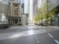 an empty city street filled with lots of tall buildings and plants growing on the sides