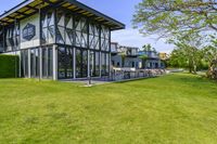 the glass walled patio and garden area has outdoor furniture on top of it with green hedges