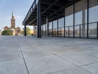 an empty courtyard area surrounded by windows and a clock tower in the distance with large buildings in the background