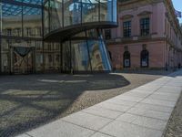 Glass Walls Reflecting Clear Skies on Cobblestone Roads