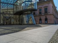 Glass Walls Reflecting Clear Skies on Cobblestone Roads