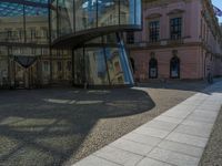 Glass Walls Reflecting Clear Skies on Cobblestone Roads