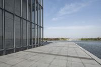 view of a very modern building by the water's edge on an open airy day