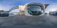 a circular structure with an unusual building and a glass window on the top floor of it