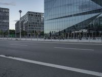 buildings in the background reflected in a glassy building window from a street corner near traffic