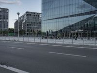 buildings in the background reflected in a glassy building window from a street corner near traffic