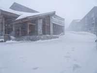 people walking through the snow in front of lodge on the slopes of a mountain resort