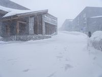 people walking through the snow in front of lodge on the slopes of a mountain resort