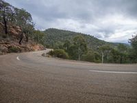 a curved road runs through the mountains in a remote area of australia with no trees