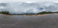 the road looks very empty during the daytime on a cloudy day, with a little bit of light in the sky