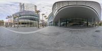 a panoramic picture of an empty building with palm trees and buildings in the background