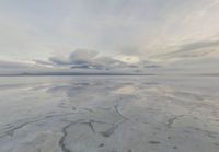 a large expanse of salt in the middle of a desert plain under a cloudy sky