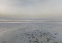 a large expanse of salt in the middle of a desert plain under a cloudy sky