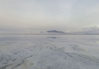 a large expanse of salt in the middle of a desert plain under a cloudy sky