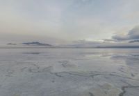 a large expanse of salt in the middle of a desert plain under a cloudy sky