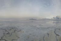 a large expanse of salt in the middle of a desert plain under a cloudy sky