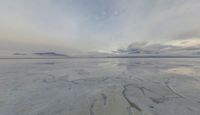 a large expanse of salt in the middle of a desert plain under a cloudy sky