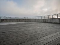 the floor is made from wood with concrete on it as a walkway is seen in the distance