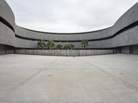 a building with cement roof near green grass and lawn in front of it, under a gray sky