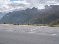 a person rides an electric skateboard across a parking space in the mountains, on an empty street and a mountain range