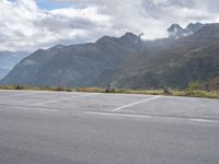 a person rides an electric skateboard across a parking space in the mountains, on an empty street and a mountain range