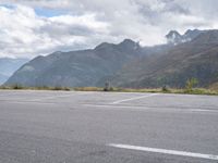 a person rides an electric skateboard across a parking space in the mountains, on an empty street and a mountain range