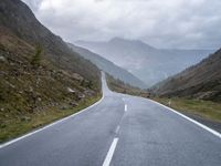 the road is narrow with many markings on it and there are rocks on both sides of the road