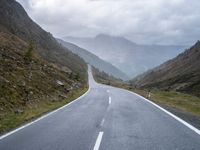 the road is narrow with many markings on it and there are rocks on both sides of the road