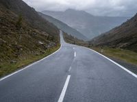 the road is narrow with many markings on it and there are rocks on both sides of the road