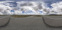 a view from a fish eye lens on an open road and blue sky with white clouds above