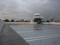 a parking lot near the water with no cars in it and a dome near the road