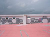 pink parking lot, with some different hexagonals on it, including a street sign