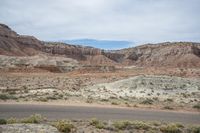 the desert is rocky and barren with mountains in the distance and clouds are in the sky