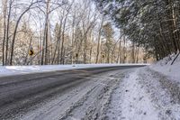 a winter road in the woods and snow on both sides and yellow signs on the middle