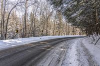 a winter road in the woods and snow on both sides and yellow signs on the middle