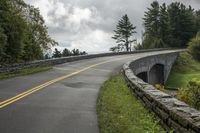 a stone roadway with a bridge spanning it's width on a cloudy day in the area