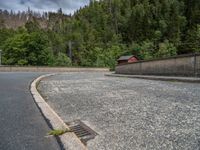 concrete walkway with trees and fenced in area on opposite sides of the road and one side of the road