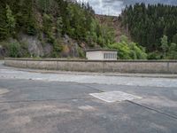 concrete walkway with trees and fenced in area on opposite sides of the road and one side of the road